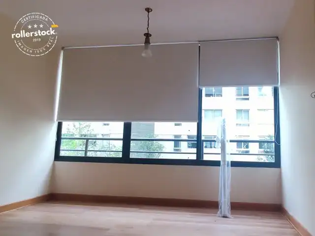 Cortinas roller blackout beige instalados en dormitorio