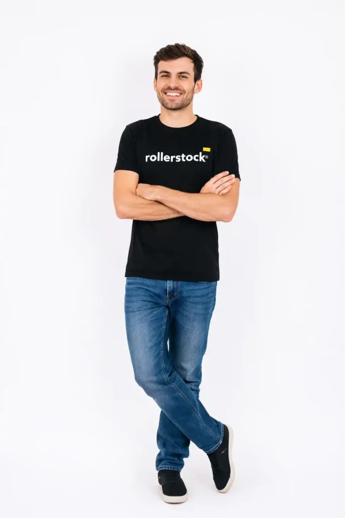 Vendedor de Rollerstock con polera negra corporativa, de pie con brazos cruzados, sonriente, representando servicio profesional de cortinas roller.